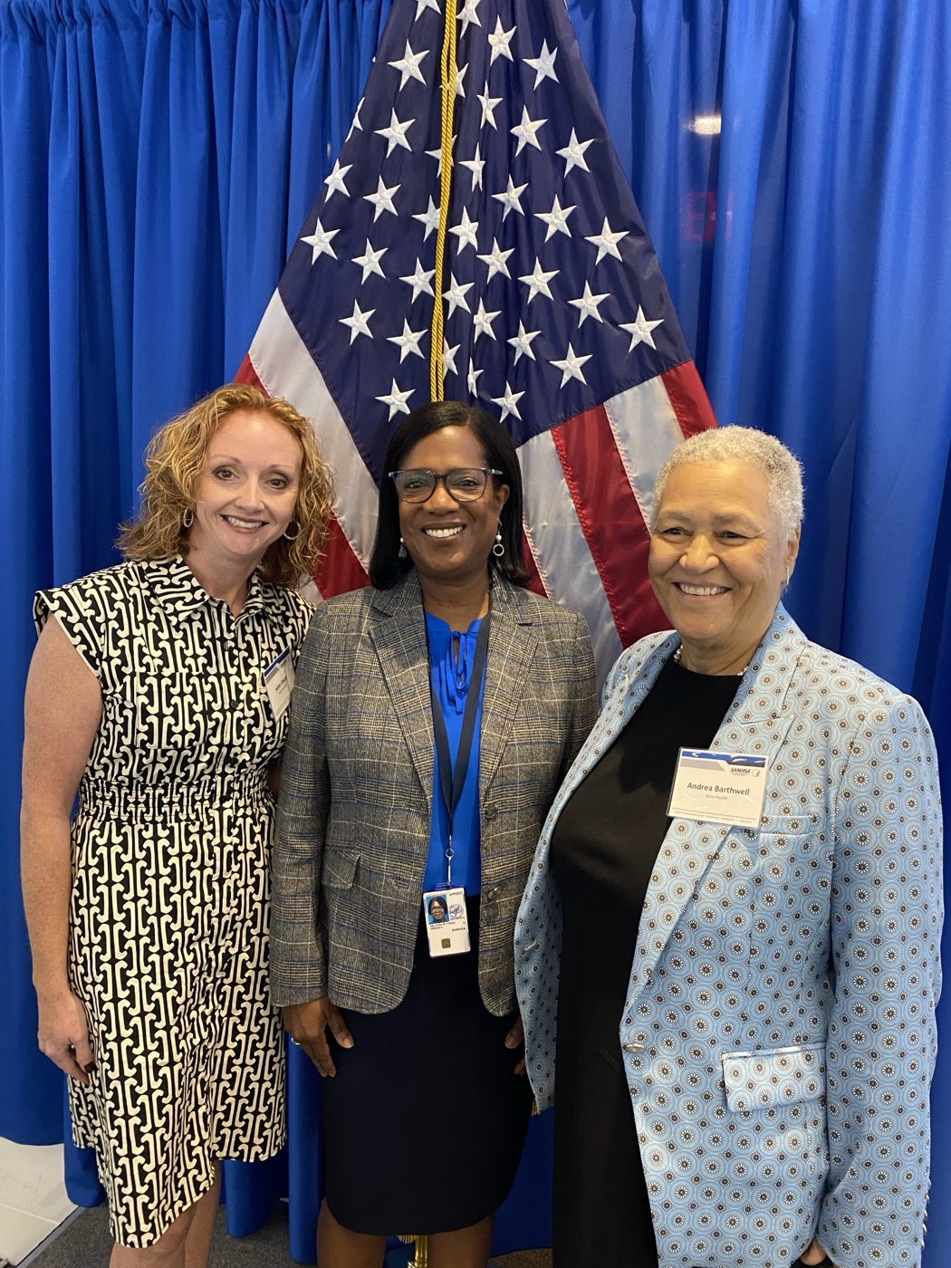 Recovery leaders, including Dr. Andrea Barthwell, gathered beside the American flag at a SAMHSA event